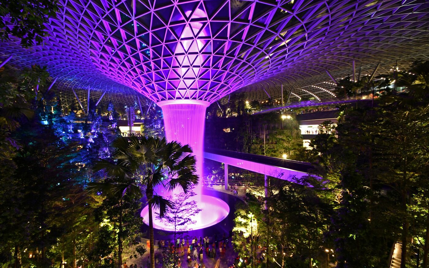 Illuminated Rain Vortex waterfall beneath the glass roof at Jewel Changi in Singapore